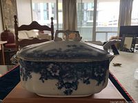 View of mustard bowl with lid on, showing blue floral pattern, gold trim, and ornate handles.