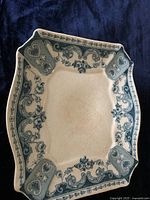 Top view of the vintage ceramic serving dish showing the blue willow pattern with floral and ornamental design on the edges.