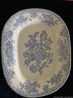 Top view of an oval white and blue pottery serving platter featuring Asiatic Pheasant floral design.