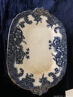 Full view of one rectangular Victorian-style porcelain platter with blue floral pattern and gold trim.