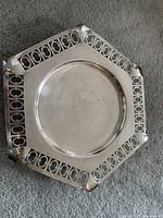 Top view of hexagonal silver plated plate showing central circular well and pierced decorative border patterns