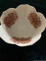 Top inside view showing lotus shaped scalloped edge with clusters of red flowers and gold accents spaced evenly inside the bowl.