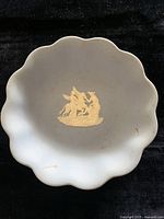 Full view of the shallow bowl showing the scalloped edge and the central white relief on blue jasperware porcelain