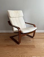 Right side view of the IKEA POÄNG armchair showing wooden bentwood frame and white padded cushions on seat and backrest.