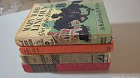 Stack of four vintage children's hardcover books showing front and spine details, some wear and minor damage visible on covers and dust jackets.