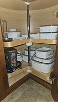 Corner cabinet with multiple Corning Ware lidded dishes, tins, and kitchen accessories