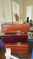 Two wooden humidor boxes stacked with Wild Turkey ceramic decanter on top and additional wooden box beneath them