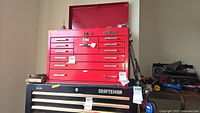 Front view of red Mac Tools tool chest sitting atop a black Craftsman chest