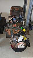 Overall view of two Buckaroo tool bags filled with assorted hand tools and accessories placed on a concrete floor in a storage area.
