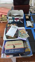 Jack Daniels trading card set, two Johnson & Johnson First Aid Travel Kits, vintage baseball cards, and Penthouse magazine arranged on table