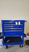 Front view of blue US General tool chest showing three drawers, top compartment, lock and keys.