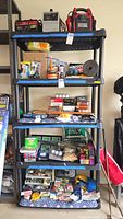 Photo showing full height of black five tier Yukon storage rack, containing various items (not included) for size reference.