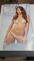 Full cover photo of 2012 calendar with a cheerleader in a beige bikini standing in water.