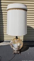 Full view of the large vintage lamp with a white fabric shade and glass floral base showing the lamp's height and general condition.