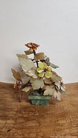 Front view of vintage Chinese gem stone bonsai tree showing carved jade and rose quartz leaves and petals in a jade pot.