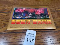Photo of souvenir folder cover showing fireworks over cityscape with Chinese text