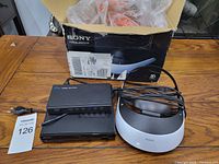 All components and box of Sony HMZ-T2 3D viewer shown on wooden table.