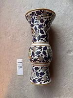 Side view of the vintage Chinese vase showing the floral and gold fruit motifs on white porcelain.