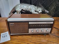 Front view of vintage Sony transistor radio showing speaker, tuning dial, and control knobs.