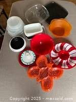 Top view of various plastic kitchen containers including bowls and trays in various colors and shapes.