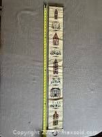 Full length photo of the hand-embroidered Dutch bell pull laid flat showing detailed building embroidery and figures.