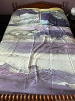 Double size duvet cover laid on bed showing abstract watercolor pattern in purple, gray, and yellow tones.