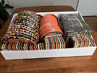 Box of Halloween-themed round paper plates and stacks of matching napkins all neatly arranged, showing the variety and quantity of items.