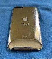 Back view of silver Apple iPod Touch model MC086C showing scratches and 8GB storage marking
