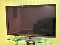 Samsung 50-inch flat screen TV front view powered off on glass stand