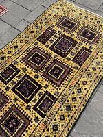 Angled view highlighting geometric square motifs and border pattern