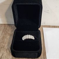 Sterling silver diamond ring in black presentation box viewed from front angle.