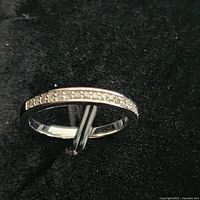 Front angled view of the sterling silver wedding band showing the row of small channel-set diamonds.