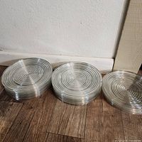 Stack of clear glass plates showing concentric circular ridges, highlighting the shape and style of the plates