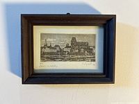 Framed black and white artist proof lithograph depicting a cityscape with buildings and a church steeple.