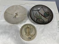 Top view of three ceramic plates showing the decorative abstract patterns and colors.