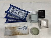 Top view of the set showing four rectangular plates, six square bowls of different colors, one small round bowl and one rectangular plate with a unique design.