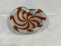Top view of a red and white swirl patterned decorative glass bowl showing the swirl pattern clearly.