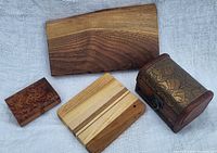 Overview of all four wooden items, two charcuterie boards and two decorative boxes.