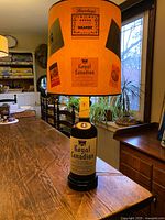 Full view of the large vintage 1960s Royal Canadian lamp showing the whisky bottle base and multi-sticker decorated lampshade.