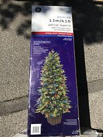 Photo of the original packaging box showing the front with brand GE, product details like height 1.3m (4.5 ft), pre-lit with LED warm white and multicolor lights, energy smart Designer Series branding, product features and energy efficiency information.