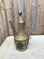 Front view of the antique copper and brass vase showing etched floral patterns and shape.