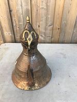 Photo showing the vintage copper vase from a top angle highlighting the ornate lid and brass decoration.