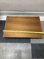 Top view of the wooden dolly showing rectangular shape with tape measure indicating approximate length.