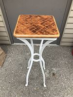 Front view of the flower stand showing detailed wooden top and white metal frame