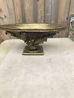 Front view of the gold-finished wood ornament tray showing ornate leaf-like carvings and pedestal base