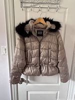 Zara Basic taupe padded jacket with black faux fur hood, front view hanging on door