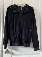 Front view of black suede Zara Man jacket with hood, zipper, and zippered pockets