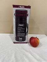 Box of the Aladdin thermos showing product details and apple for size comparison.