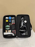 Microscope science kit items in black case with various accessories and tools