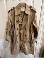 Front view of the beige Zara trench coat showing double-breasted button design, collar, and epaulets